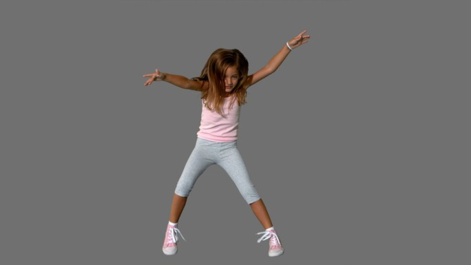小女孩在灰色背景上跳跃的慢镜头