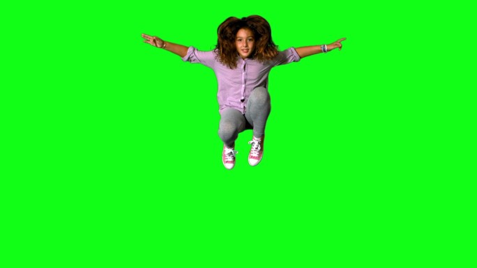 快乐的小女孩在绿色屏幕上跳上跳下的慢动作