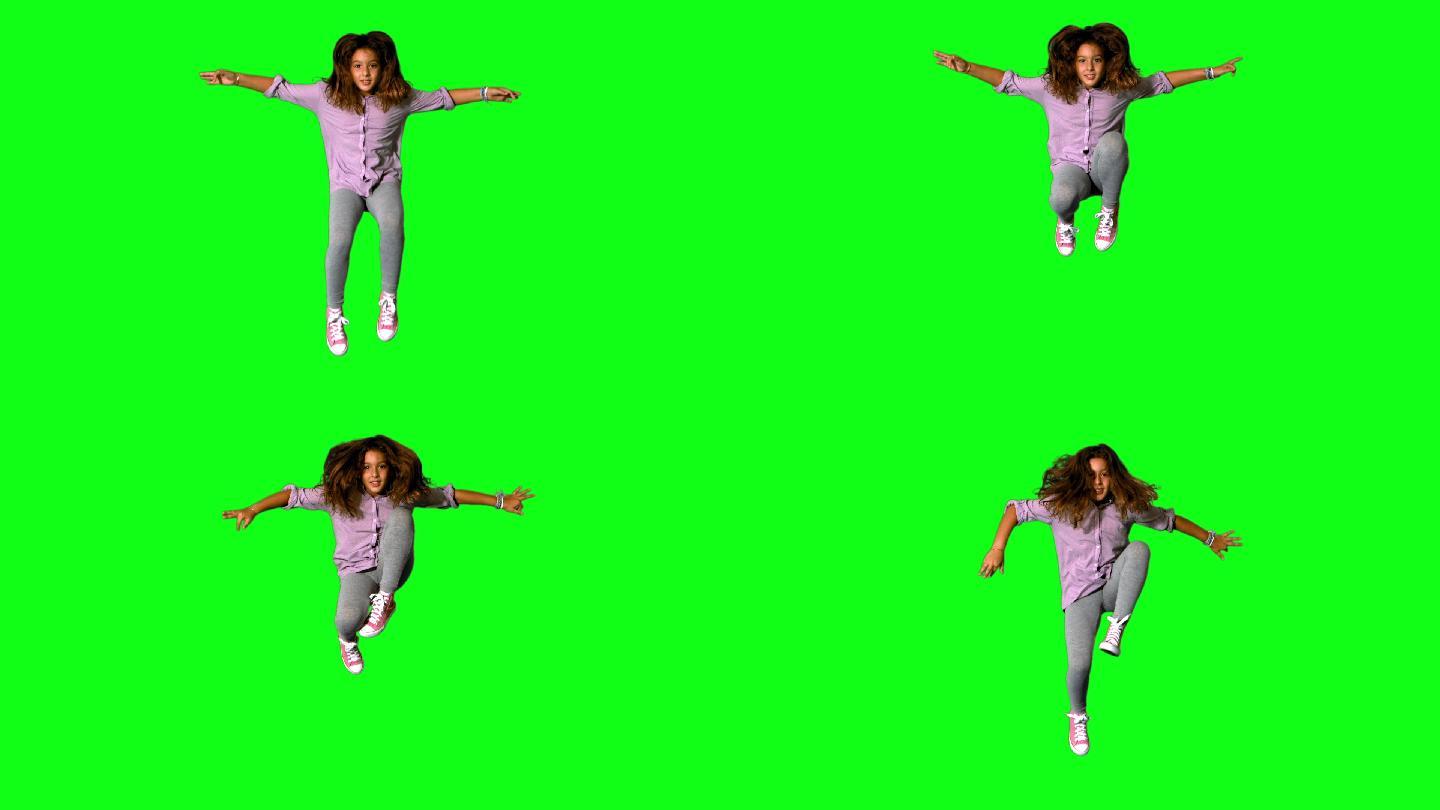 快乐的小女孩在绿色屏幕上跳上跳下的慢动作