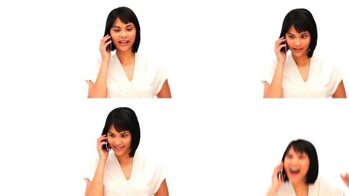 一个随意的亚洲女人在一个白色的背景下讲电话