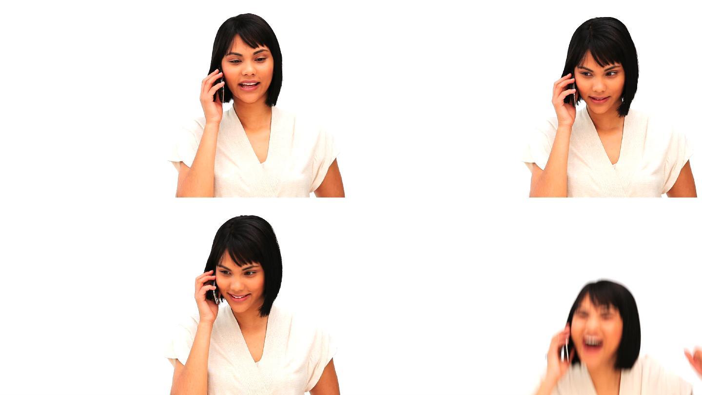 一个随意的亚洲女人在一个白色的背景下讲电话
