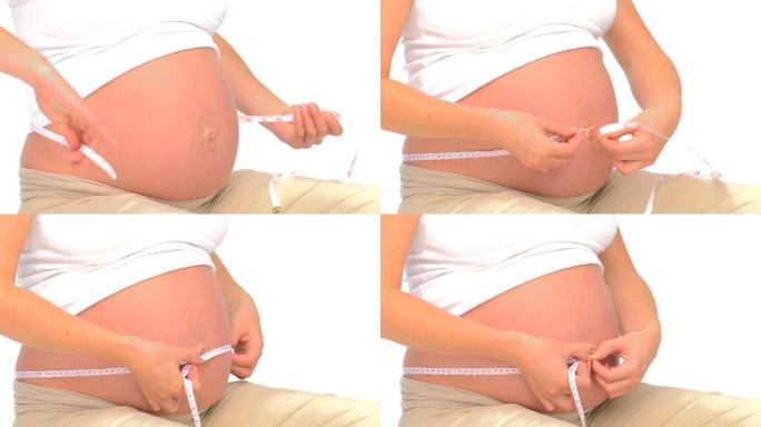 一名孕妇在白色背景下使用卷尺