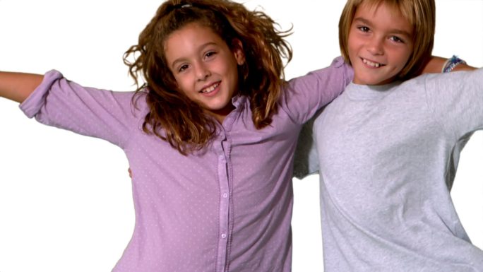 哥哥和妹妹跳进同一个镜头，拥抱在白色背景的慢动作