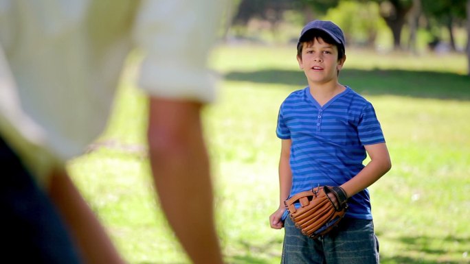 微笑的男孩站在乡村打棒球