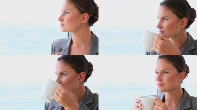 一个在窗边喝热咖啡的女人