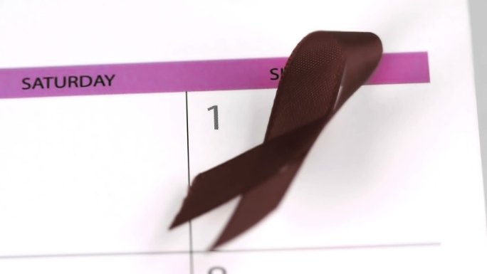 红丝带象征着艾滋病以慢镜头落在日历上