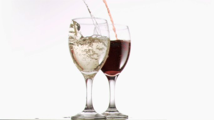 向两个红酒杯倒酒在白色背景下慢镜头