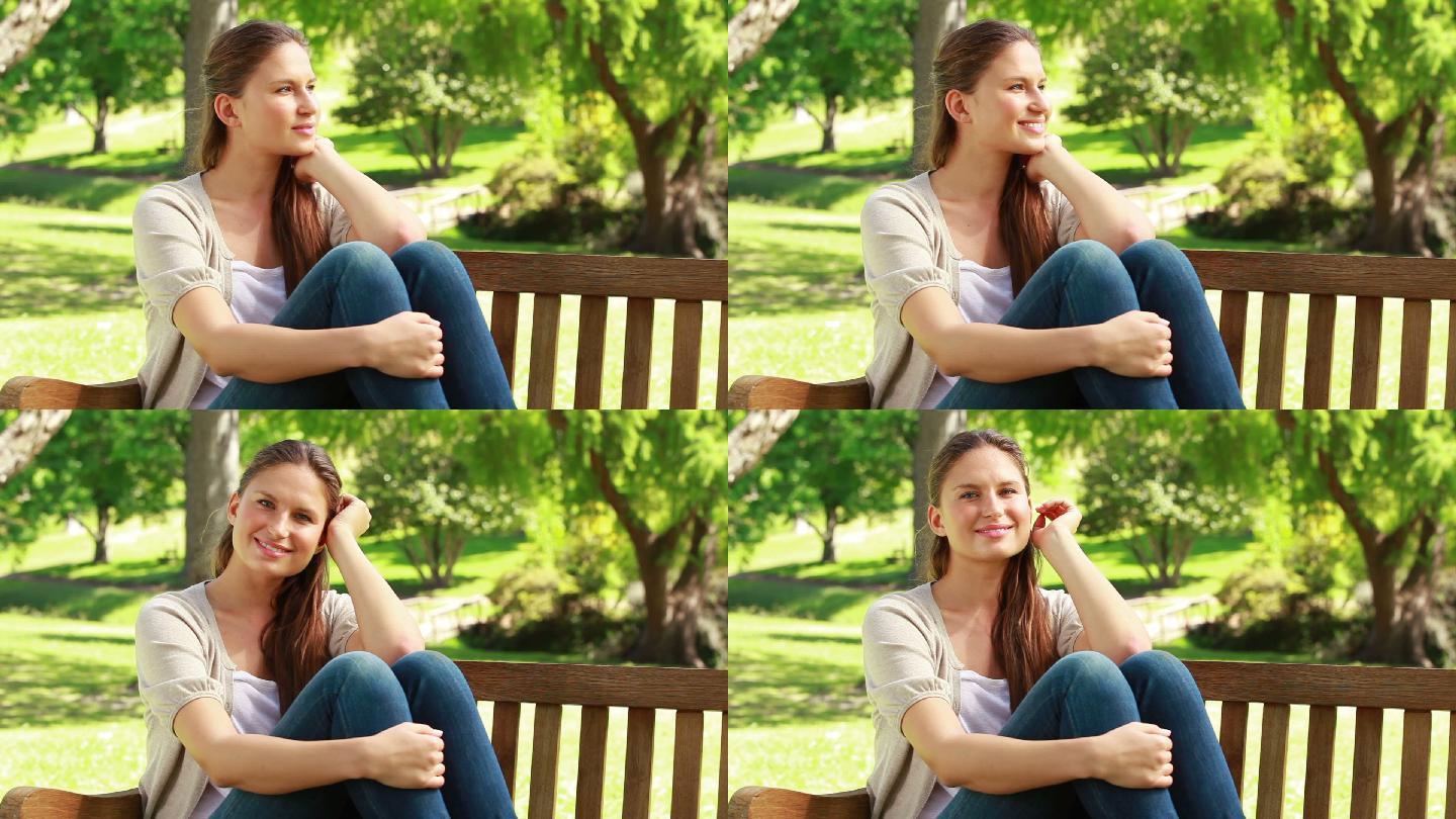坐在公园长椅上微笑的女人