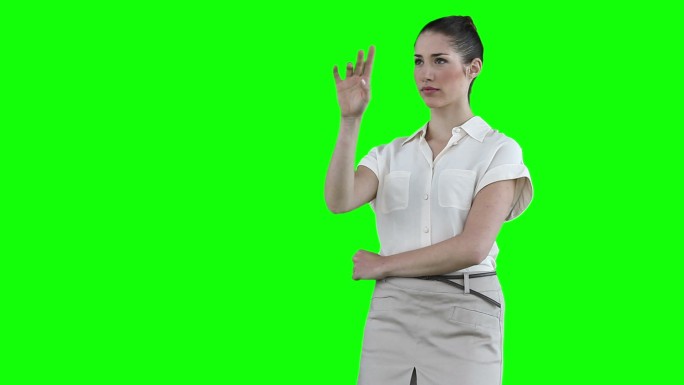 女商人站在绿色背景下使用虚拟触摸屏