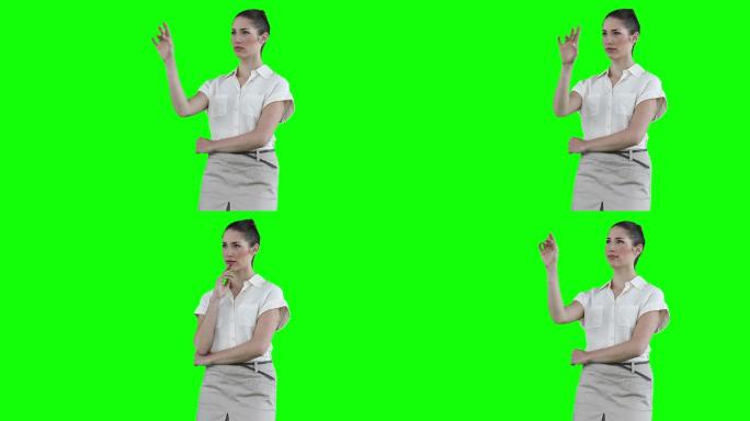 女商人站在绿色背景下使用虚拟触摸屏