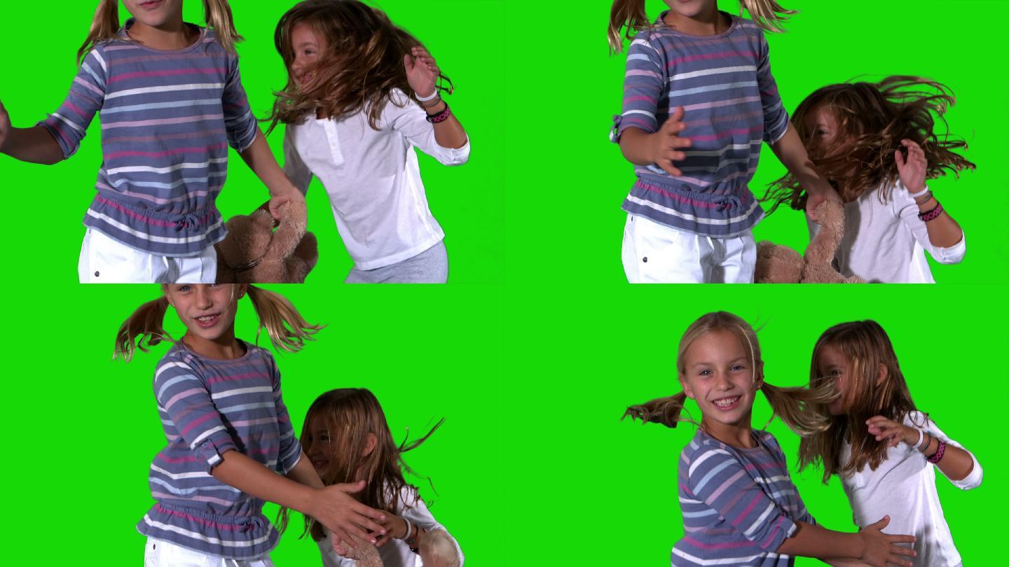 姐妹们跳跃在绿色屏幕上与泰迪熊在慢动作