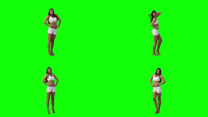 一个女人在绿色背景下为相机摆姿势