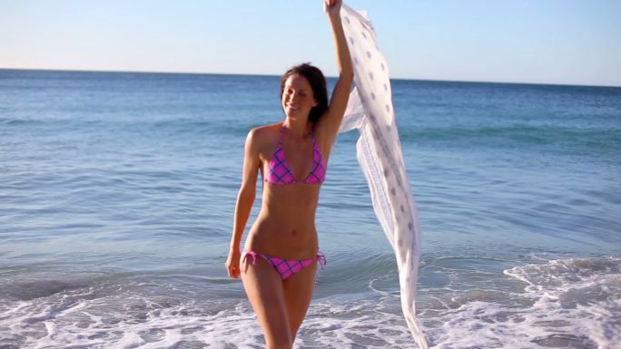 一个女人在海滩上撩起她的纱笼