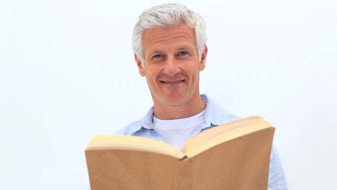 一个退休男子在白色背景下看书
