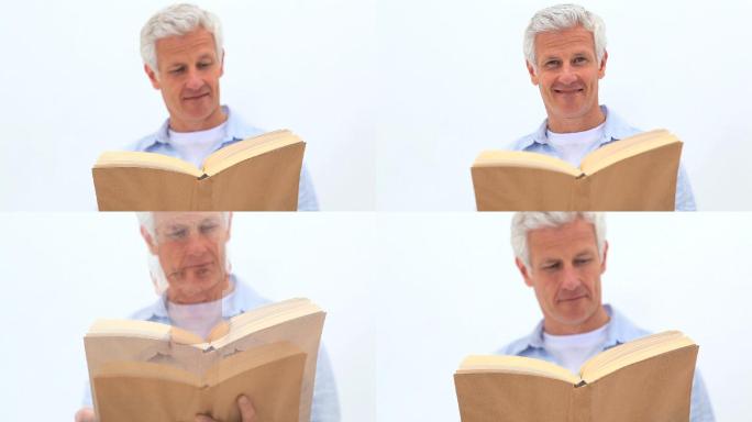 一个退休男子在白色背景下看书
