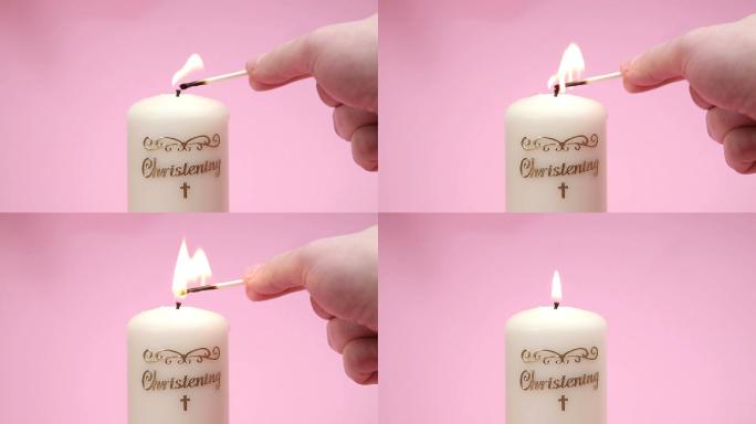 在粉红色背景上点燃的洗礼蜡烛