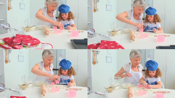 祖母在教她的孙女如何在厨房烘焙
