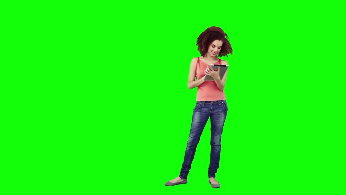 一位女士正在绿色背景下使用平板电脑
