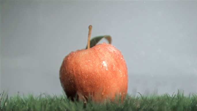 水落在红苹果上慢镜头，在灰色背景下