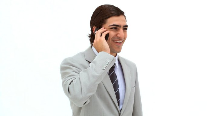 在白色背景下用手机微笑的男人