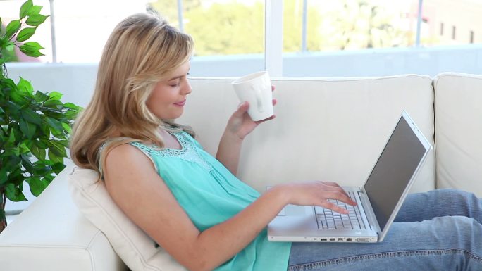 金发女人在客厅里用手提电脑