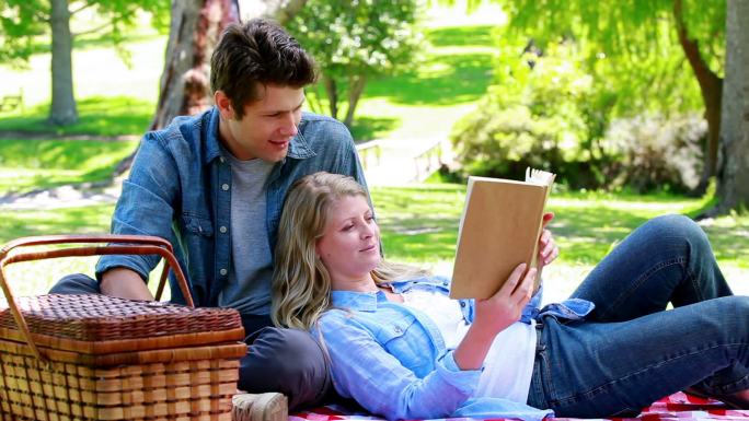一对情侣在公园里一起看书