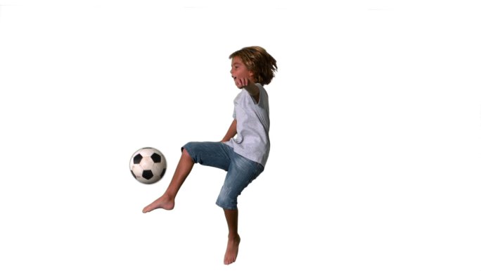 一个西方男孩踢足球慢动作，在白色背景下
