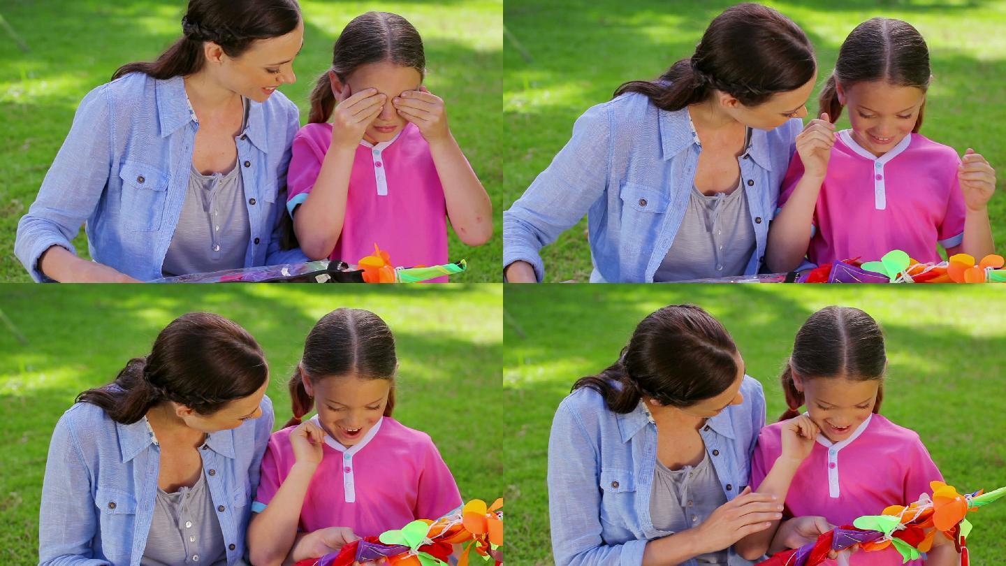 小女孩和她的妈妈在公园里接受风筝