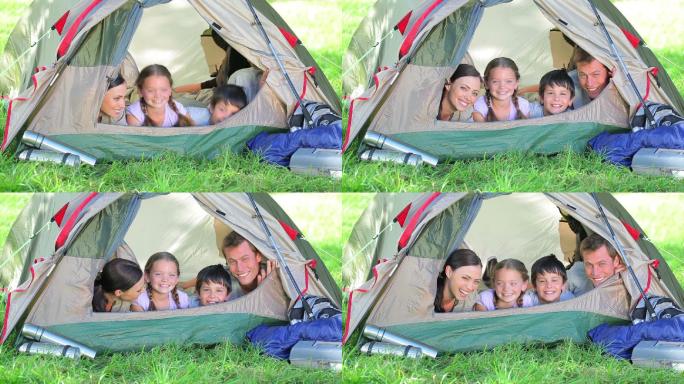 微笑的一家人躺在乡村的一个帐篷里