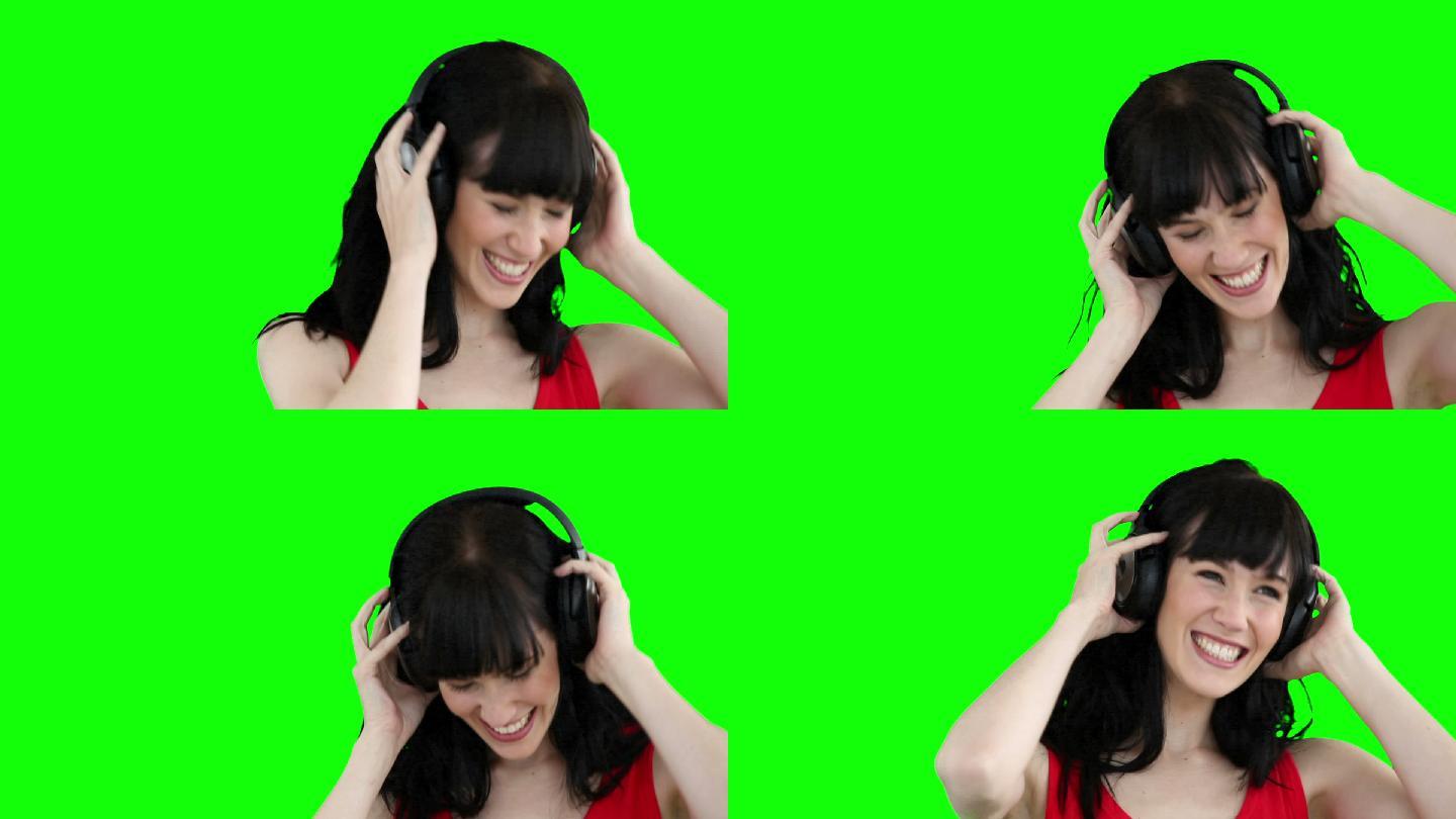 一名女子戴着耳机在绿色背景下跳舞