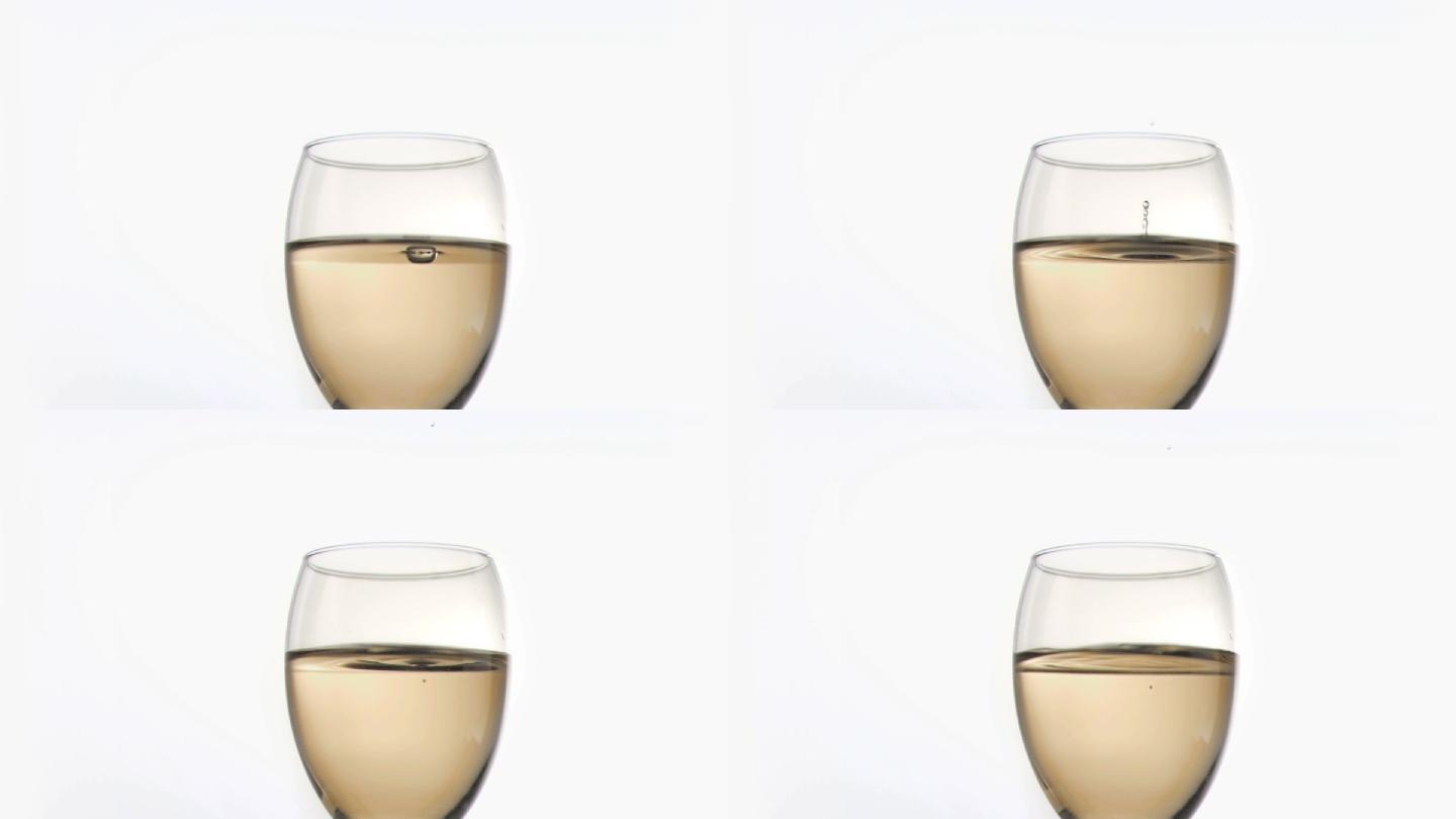 一滴液体落入白色背景下的酒杯中慢镜头