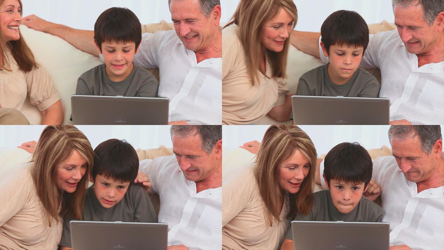 爷爷奶奶和孙子在笔记本电脑上玩游戏