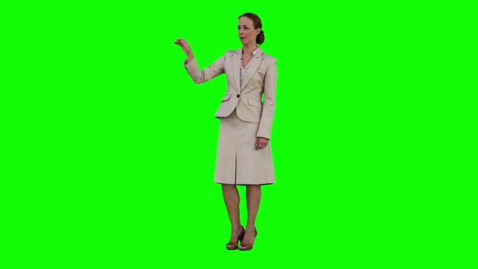 一位女商人正在绿色背景下使用虚拟触摸屏