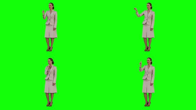 一位女商人正在绿色背景下使用虚拟触摸屏