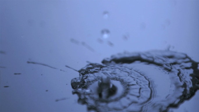 水滴以极慢的速度落在光滑的表面上，并发出蓝光