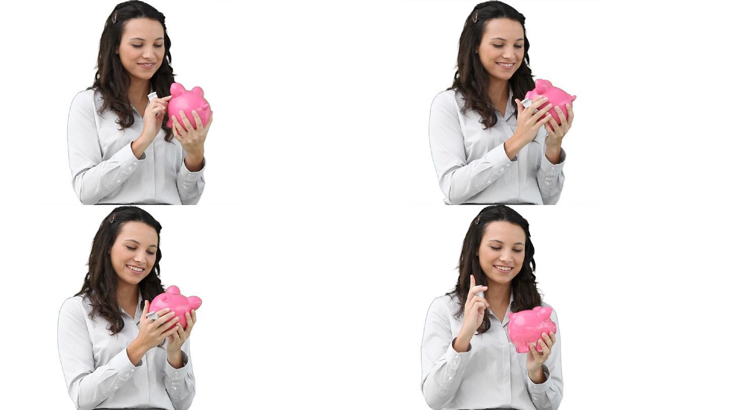 在白色的背景下，一个女人揉着一个存钱罐