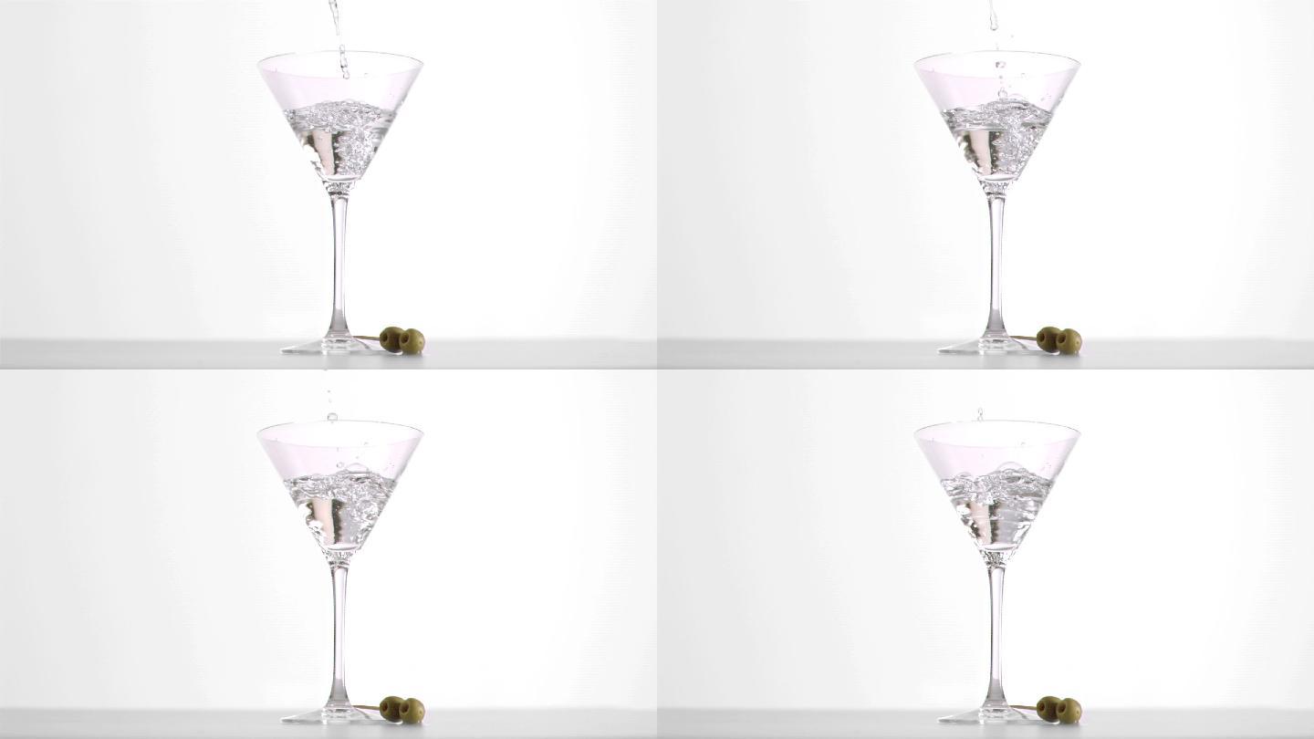 伏特加马提尼以超慢的动作倒进白色背景的玻璃杯中