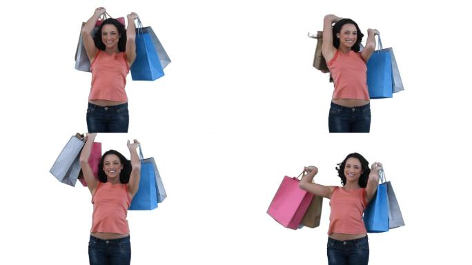 拿着购物袋的女人对着白色的背景微笑