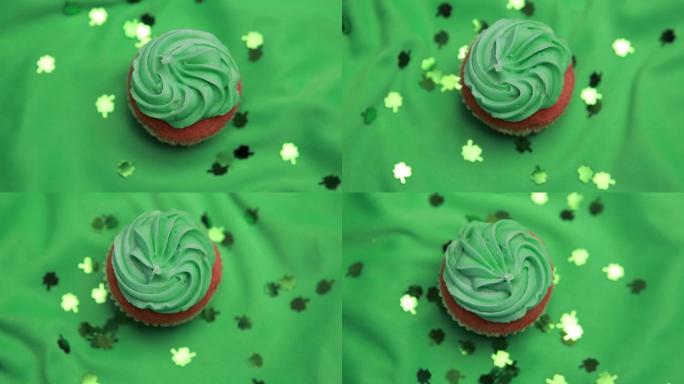圣帕特里克节纸杯蛋糕旋转着，三叶草的五彩纸屑落在绿色的表面上