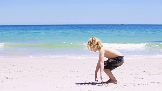 金发小孩在沙滩上倒立