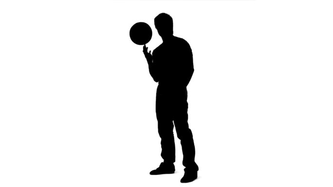 在白色背景下，一个男人在手指上平衡一个球的慢动作剪影