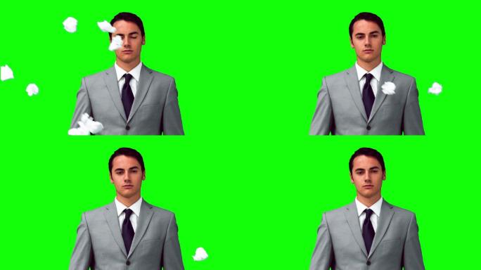 一个人在绿色背景下站在纸球下的慢镜头