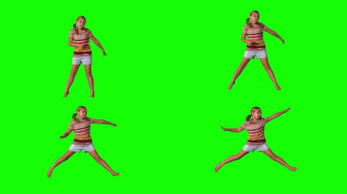 女孩在绿色屏幕上伸开四肢跳跃的慢动作