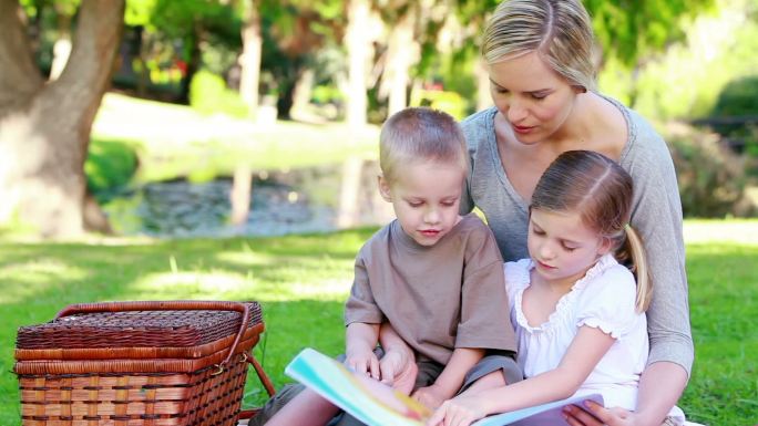 妈妈和她的孩子们在公园里看图画书