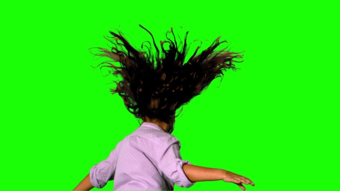 女孩在绿色屏幕上跳跃和旋转的慢动作