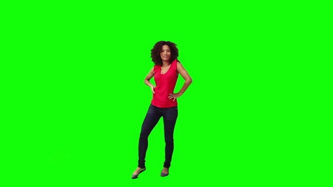 一个年轻的黑发女子在绿色背景前跳舞