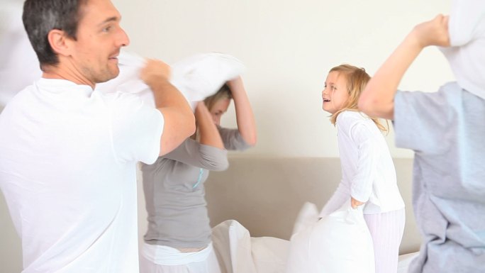 一家人在父母的卧室里玩枕头大战