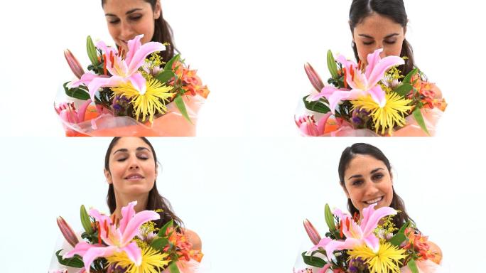 一个面带微笑的女人举着一束花，背景是白色的