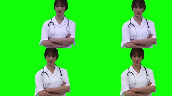 一位女医生在绿色背景下交叉双臂走了进来