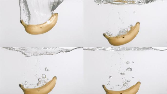在白色背景下，一只香蕉以超慢的动作落在水中